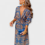 Elegant long-sleeve V-neck dress in blue and gold ornate print, knotted waist tie
