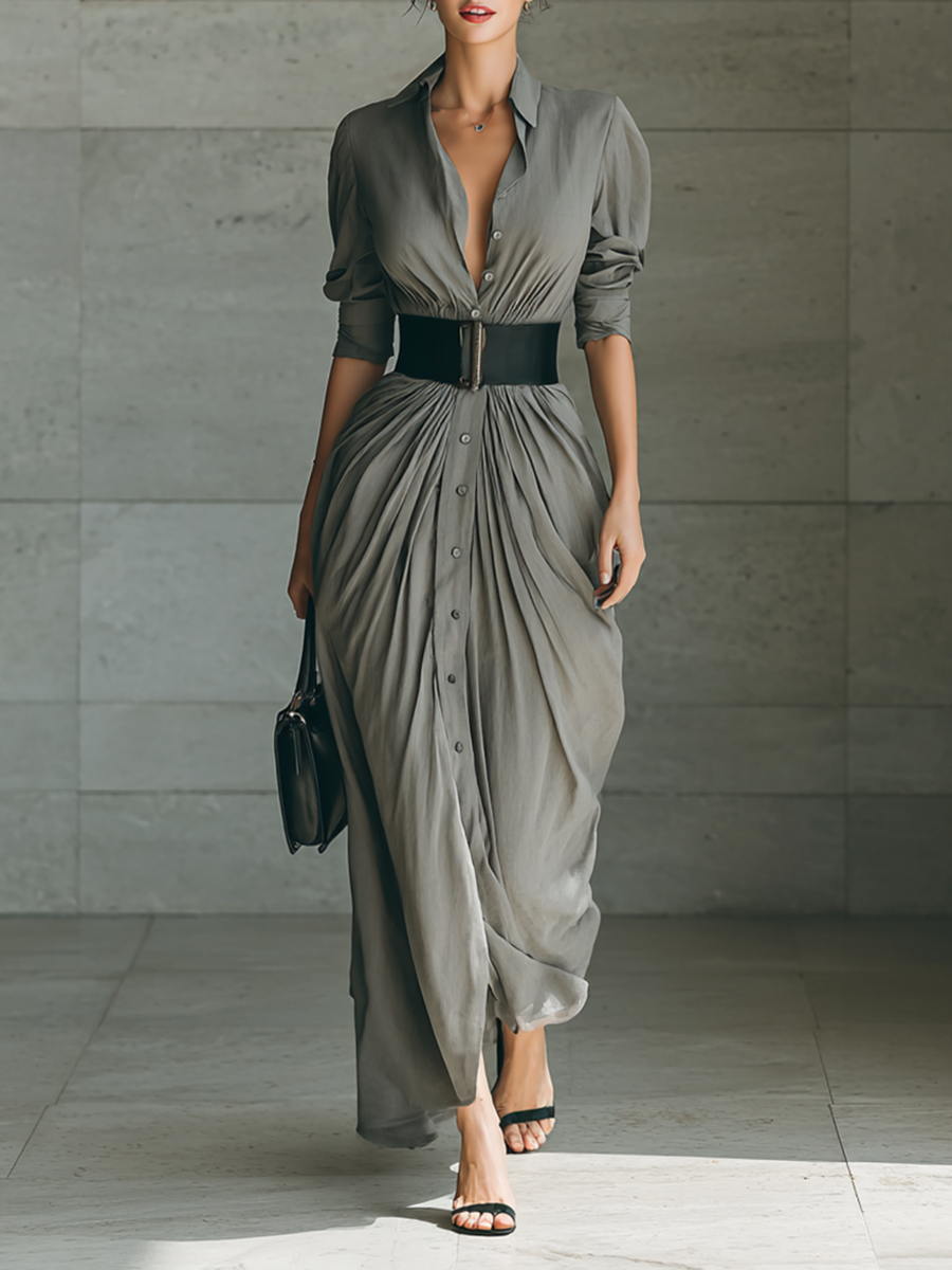 Long pleated grey dress with button front, belted waist, and three-quarter sleeves