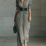 Long pleated grey dress with button front, belted waist, and three-quarter sleeves