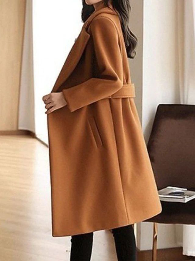 Tan winter coat with notch lapels, waist belt, and long sleeves