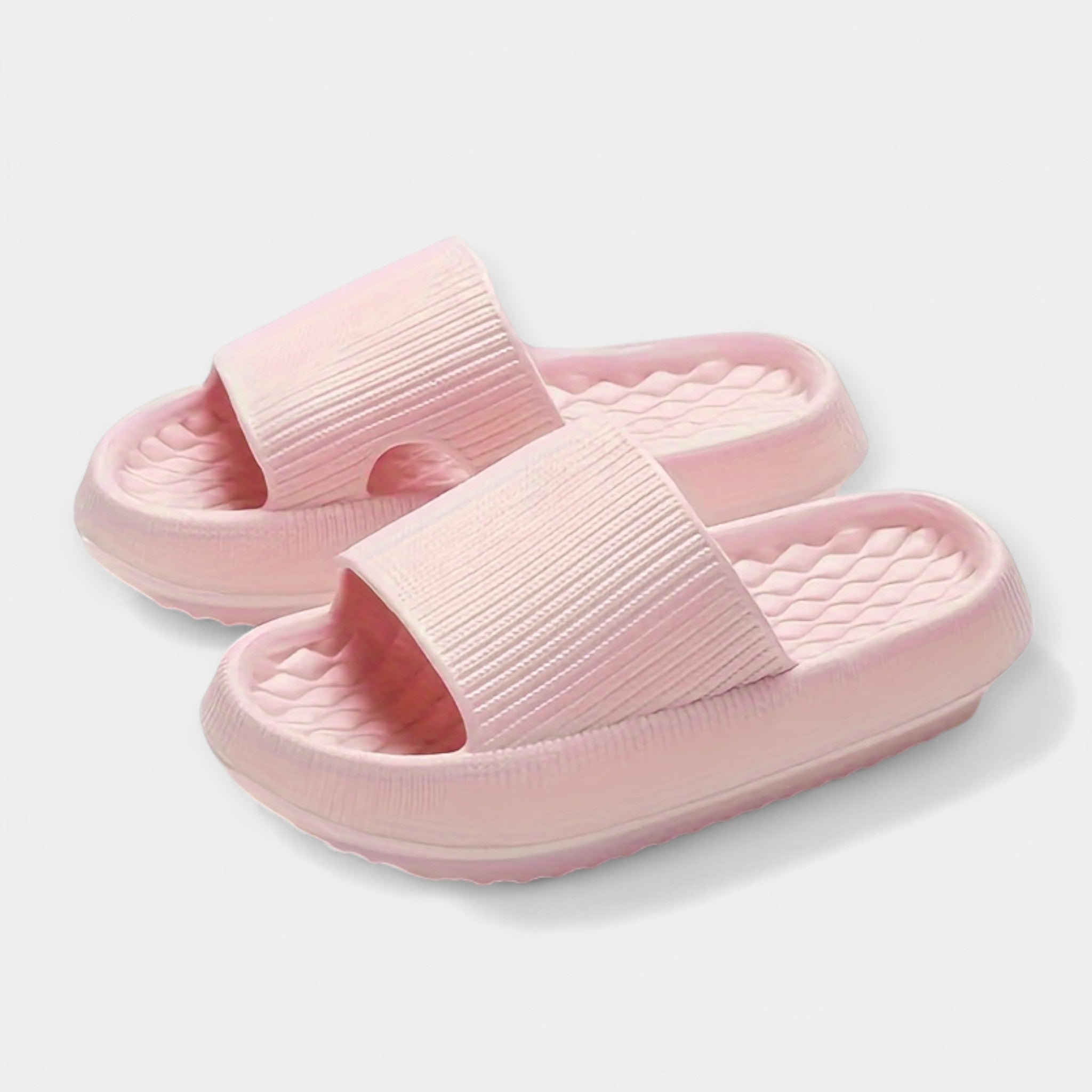 Light pink textured slide sandals with thick cushioned sole and quilted footbed