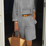 Gray blazer and shorts set with belted waist detail, tailored shoulder seams.
