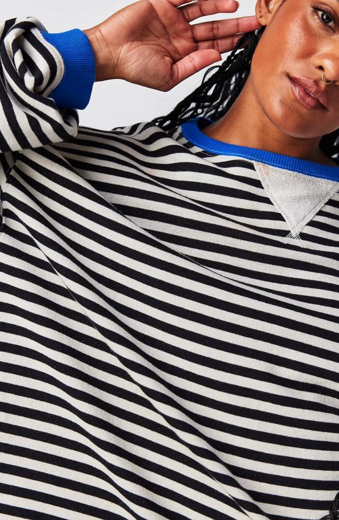 Black and white striped pullover with blue trim around neckline and cuffs