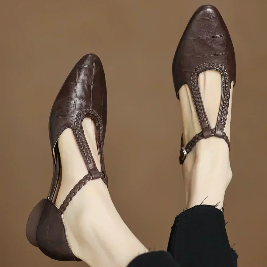 Brown leather pointed-toe flats with ankle strap and braided trim