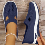 Navy orthopedic knit slip-on sneakers with breathable side cutouts and white sole