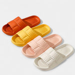 Assorted lightweight slide sandals in orange, yellow, pink, and white, padded straps