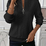 Black cable-knit zip-front sweater with half zipper and long sleeves, textured braid pattern.
