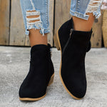 Black suede ankle boots with side zipper, block heel, worn with light blue jeans.
