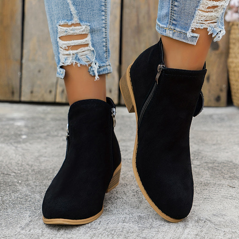 Black suede ankle boots with side zipper, block heel, worn with light blue jeans.
