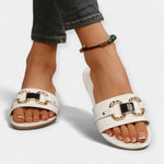 White round-toe sandals with wide straps and decorative gold buckles, open toe
