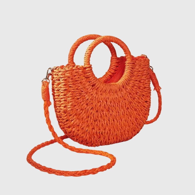 Woven straw shoulder bag in orange with loop handles and long crossbody strap.