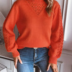 Orange knit pullover with textured V yoke and ribbed cuffs, long sleeves