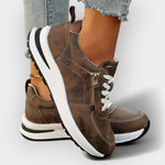 Anatomical brown sneakers with white laces, side zipper, and thick white sole.