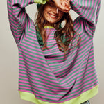 Green and pink striped relaxed pullover with neon yellow cuffs and long sleeves