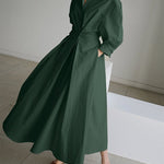 Dark green long wrap-style dress with puff sleeves and tied waist, flowing full skirt