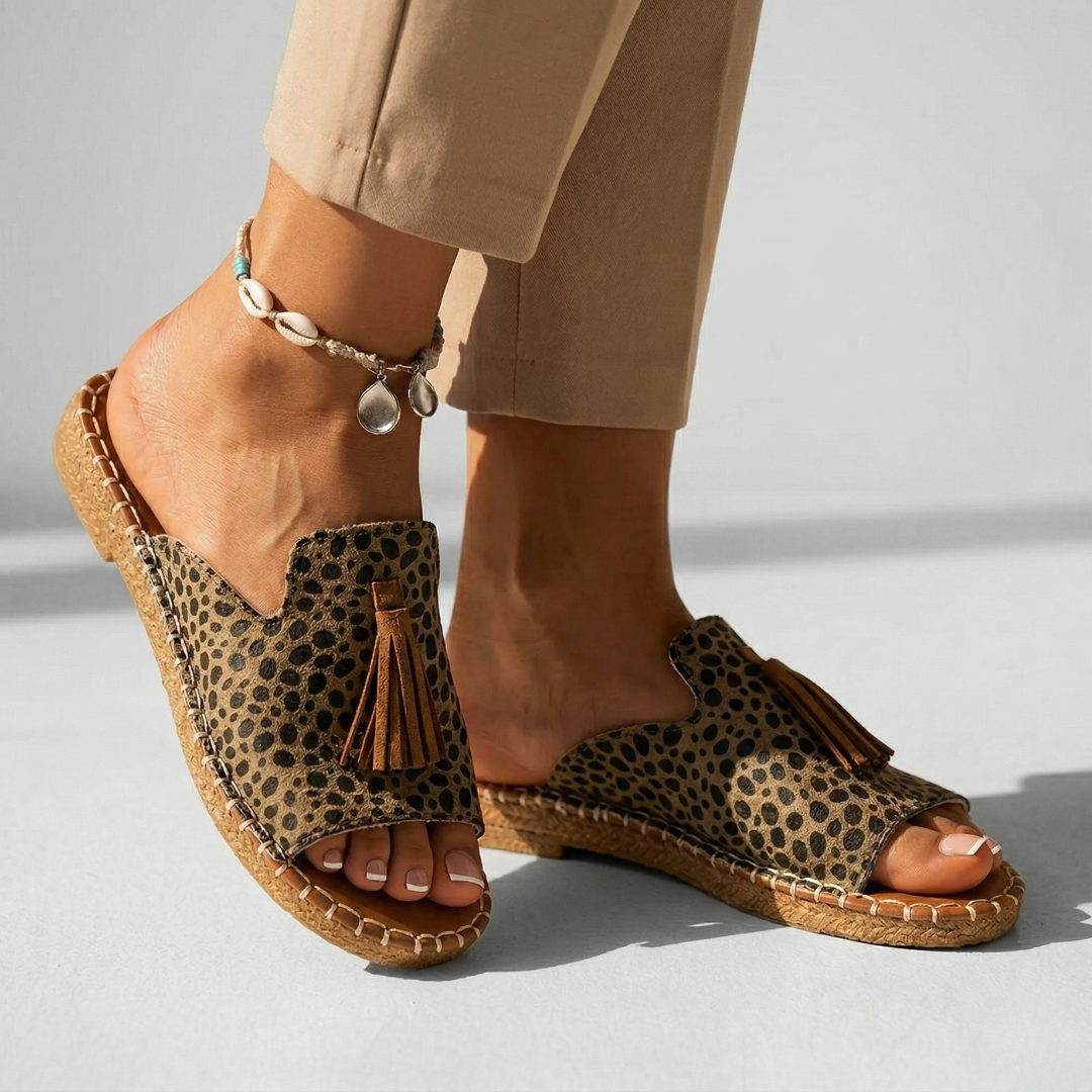 Platform slide sandals with leopard-print upper and brown tassel, open toe, tan stitched sole