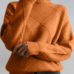 Rust orange high-neck sweater with ribbed turtleneck and diagonal knit panel detail.