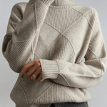 Beige high-neck sweater with ribbed turtleneck and diagonal knit panel detail.