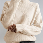 Cream high-neck sweater with ribbed turtleneck and diagonal knit panel detail.