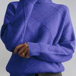Royal blue high-neck sweater with ribbed turtleneck and diagonal knit panel detail.