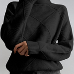 Black high-neck sweater with ribbed turtleneck and diagonal knit panel detail.