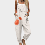 Loose printed overalls in white with orange abstract pattern, adjustable straps and front pockets