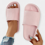 Soft pink slide sandals with ribbed footbed and wide open toe strap