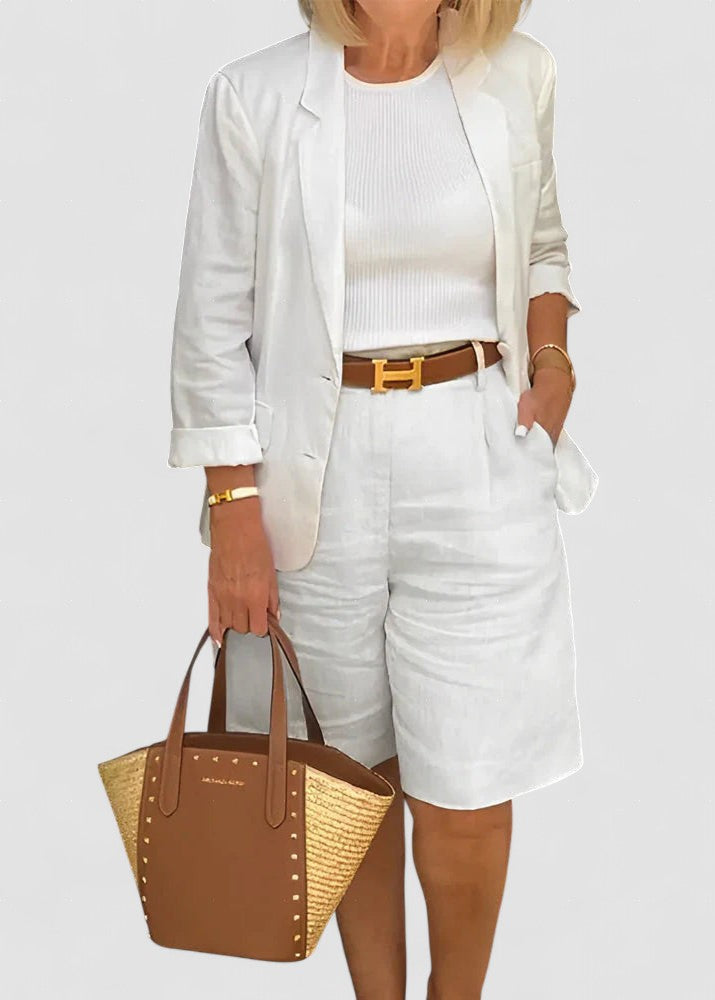 White blazer and shorts set with belted waist detail, structured cuffs.