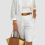 White blazer and shorts set with belted waist detail, structured cuffs.