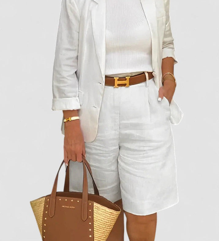 White blazer and shorts set with belted waist detail, structured cuffs.