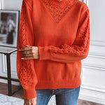 Orange knit sweater with textured V neckline and long sleeves, ribbed cuffs