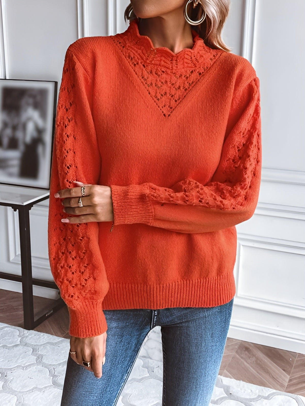 Orange knit sweater with textured V neckline and long sleeves, ribbed cuffs