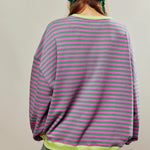 Back view: green and pink striped relaxed pullover with neon yellow hem