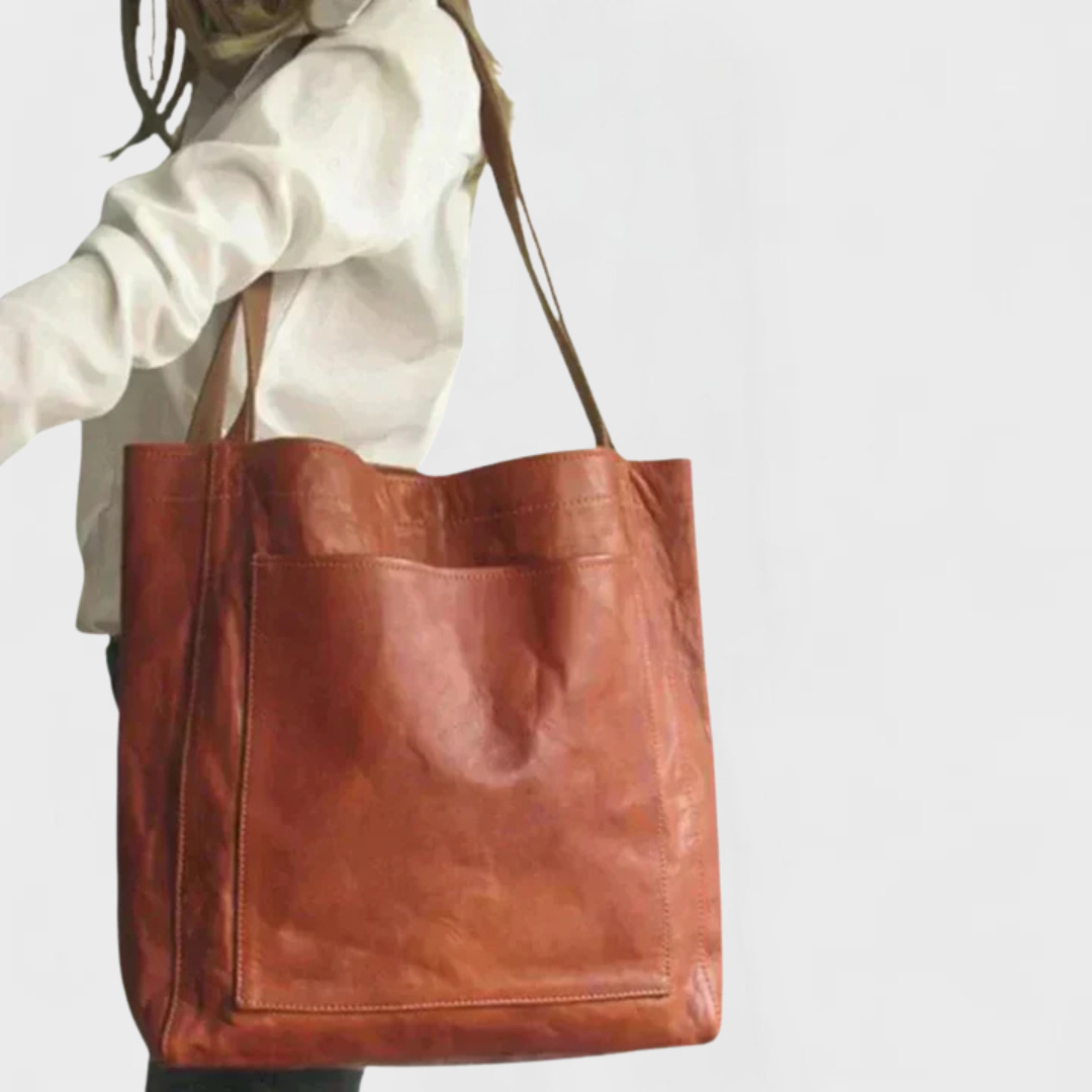 Rust brown leather tote bag with double top handles and front stitched panel.