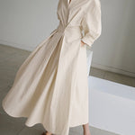 Beige long wrap-style dress with puff sleeves and tied waist, full skirt