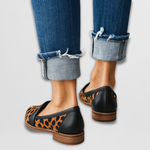 Black leather moccasin loafers with leopard-print inlay and stacked wood-look sole.