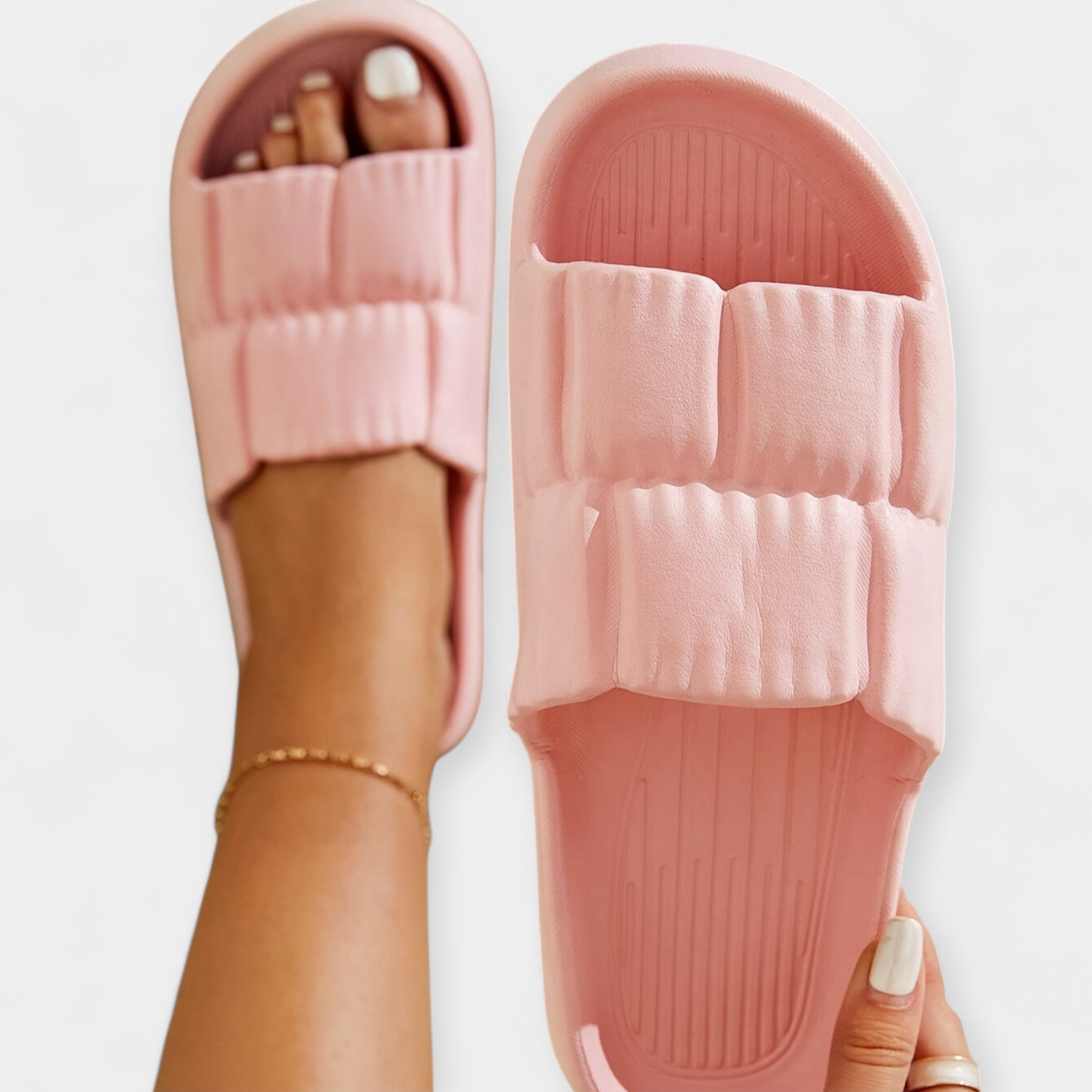 Light pink slide sandals with padded strap and ridged footbed, close-up