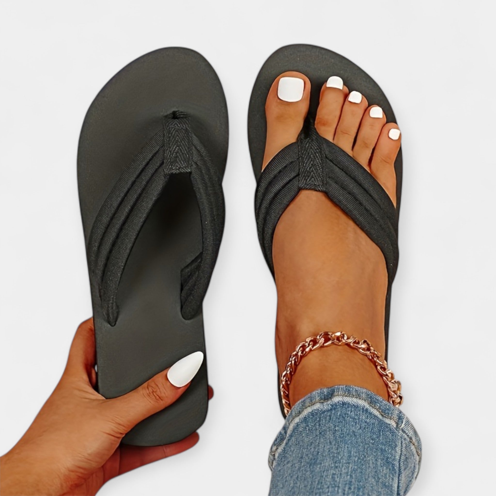Black flip-flop sandals with textured thong strap, flat sole