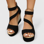 Black platform wedge sandals with wide straps and open-toe design