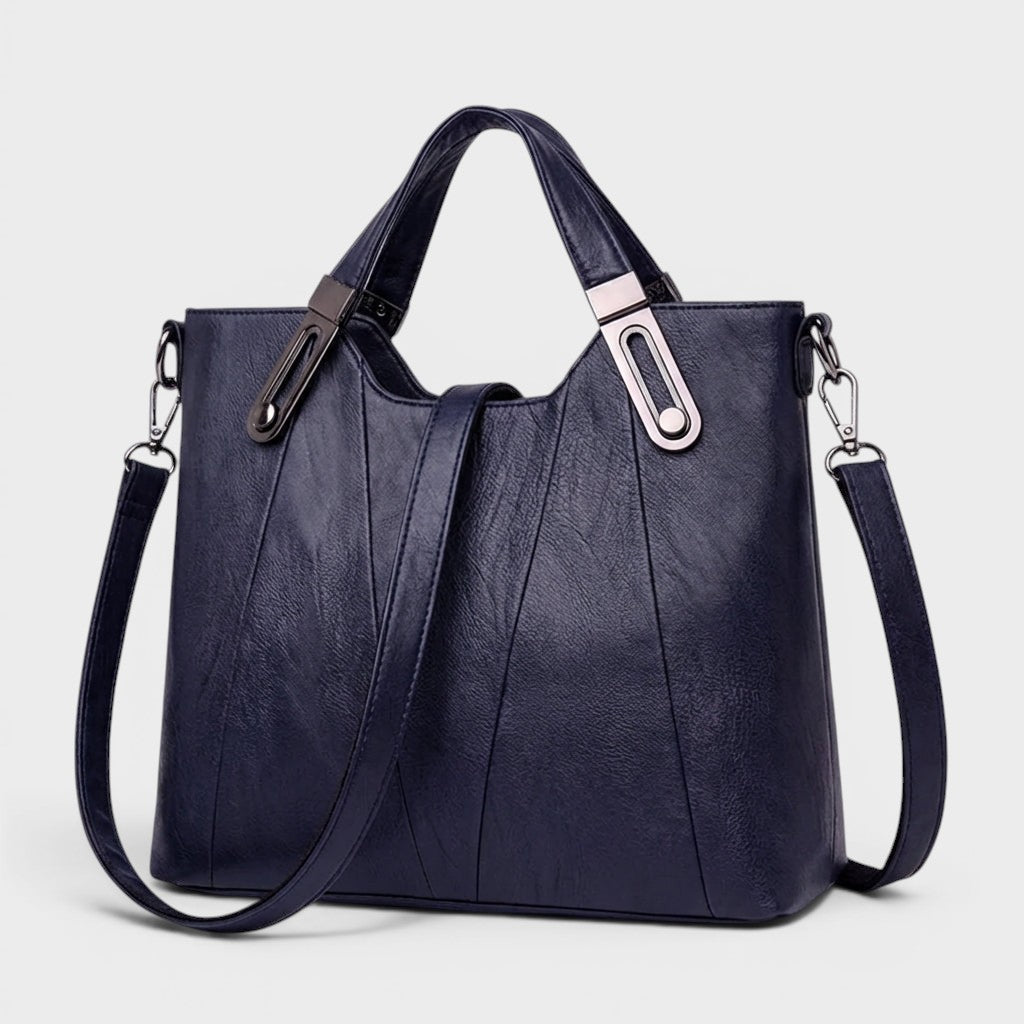 Navy leather handbag with grain texture, top handles, and shoulder strap