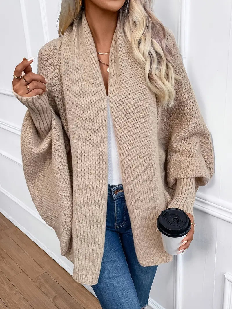 Beige knit cardigan with open front and long sleeves, chunky textured knit.