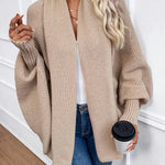 Beige knit cardigan with open front and long sleeves, chunky textured knit.