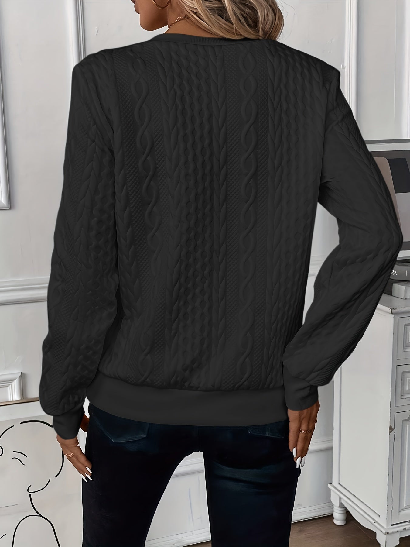 Black cable-knit zip-front sweater, back view, long sleeves with textured braid pattern.