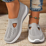 White orthopedic knit slip-on sneakers with breathable side cutouts and cushioned sole