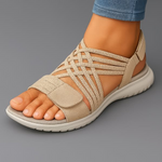 Orthopedic sandal in beige with open toe, woven upper, and cushioned thick sole.