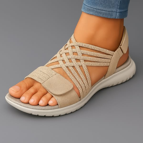 Orthopedic sandal in beige with open toe, woven upper, and cushioned thick sole.