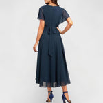 Catalina V-neck midi dress back view, short flutter sleeves, tied waist and flowing skirt