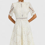 White lace midi dress close-up, high neckline and textured floral eyelet pattern
