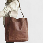 Dark brown leather tote bag with double top handles and front stitched panel.