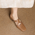 Tan natural leather mule flats, side view showing low block heel and cutout strap